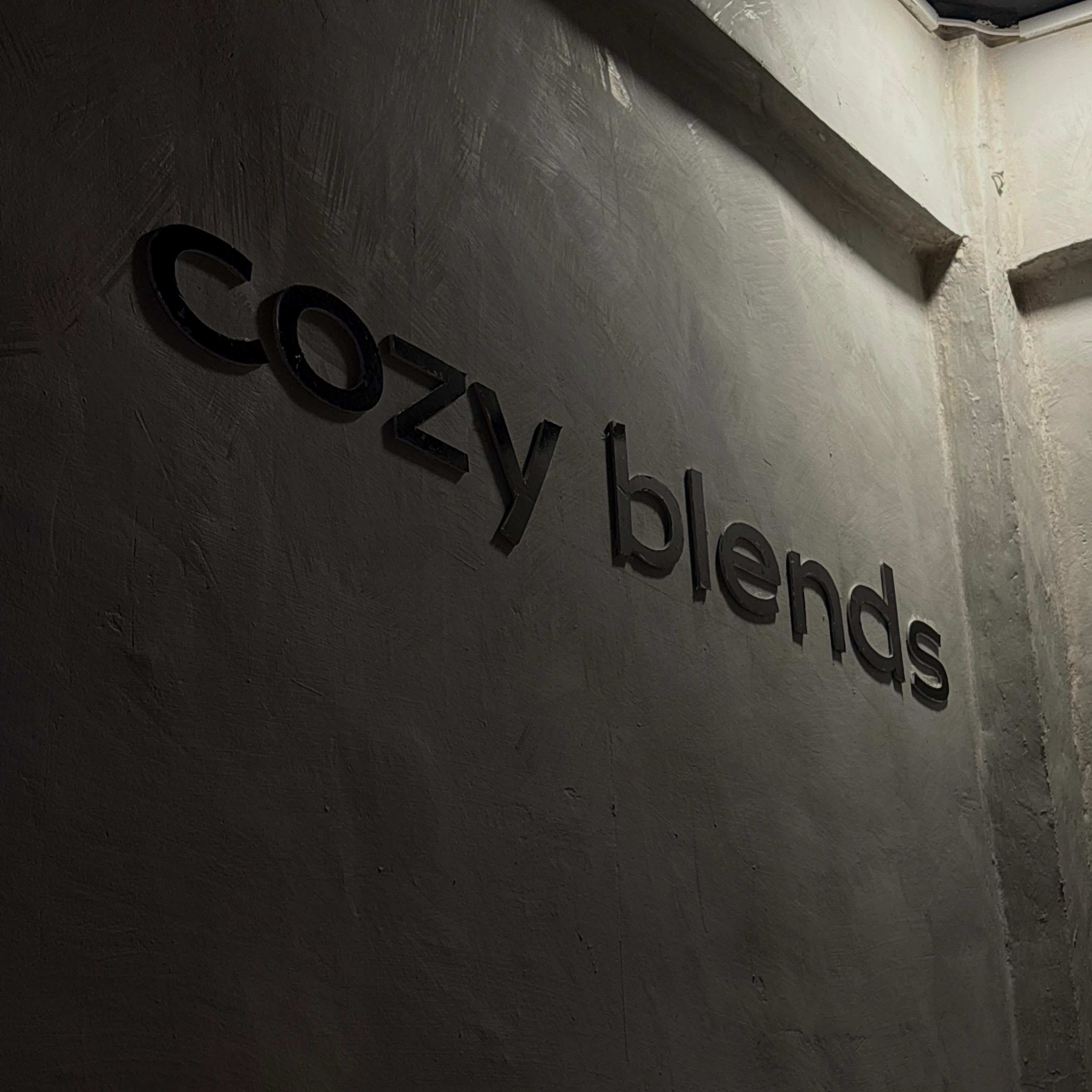 The cozy blends lettering mounted on a hand-troweled concrete wall